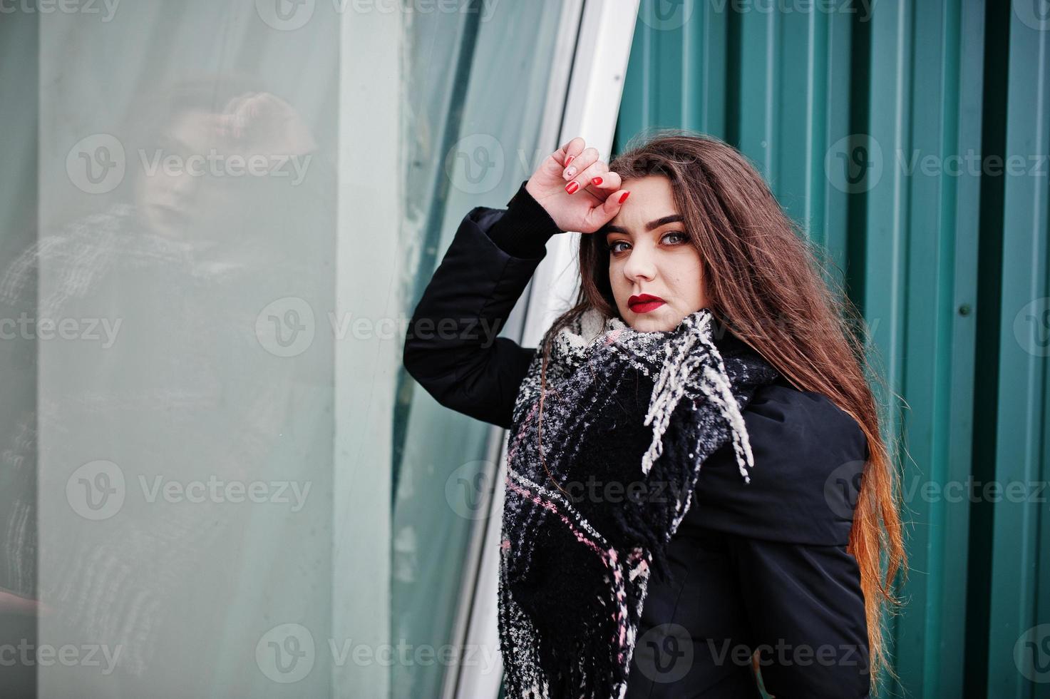 brünettes stilvolles lässiges mädchen im schal gegen grüne metallische wand. foto