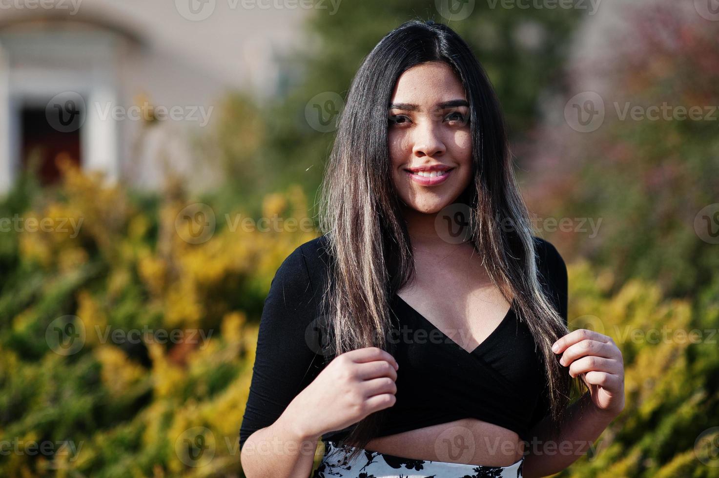 hübsches latino-model-mädchen aus ecuador trägt schwarze oberteile und rock auf der straße. foto