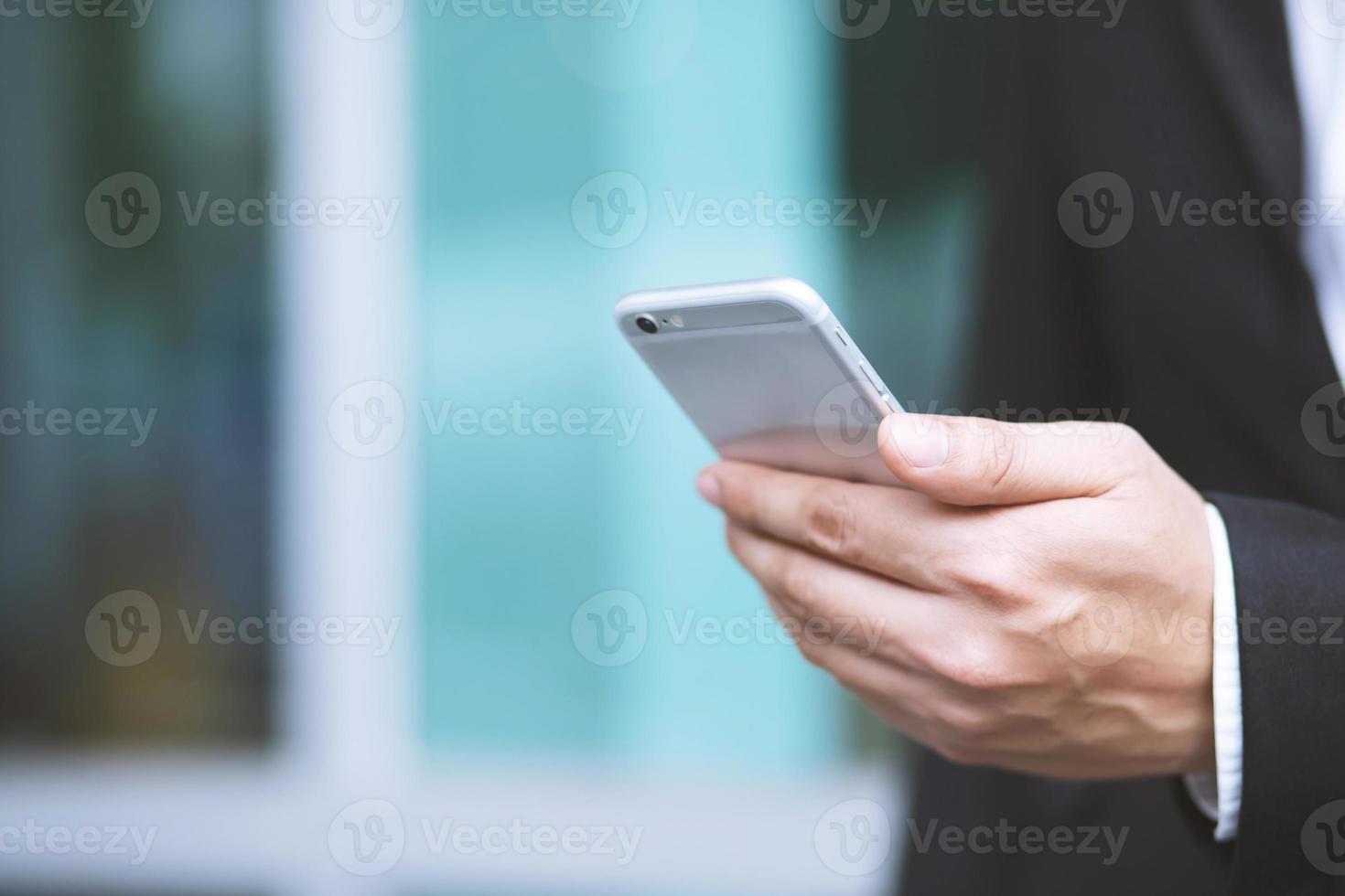 Nahaufnahme einer Hand eines Mannes, die mit einem Mobiltelefon im Freien einen Sitzstuhl im öffentlichen Park verwendet. mit Filtertönen Vintage-Effekt, warme Töne. foto