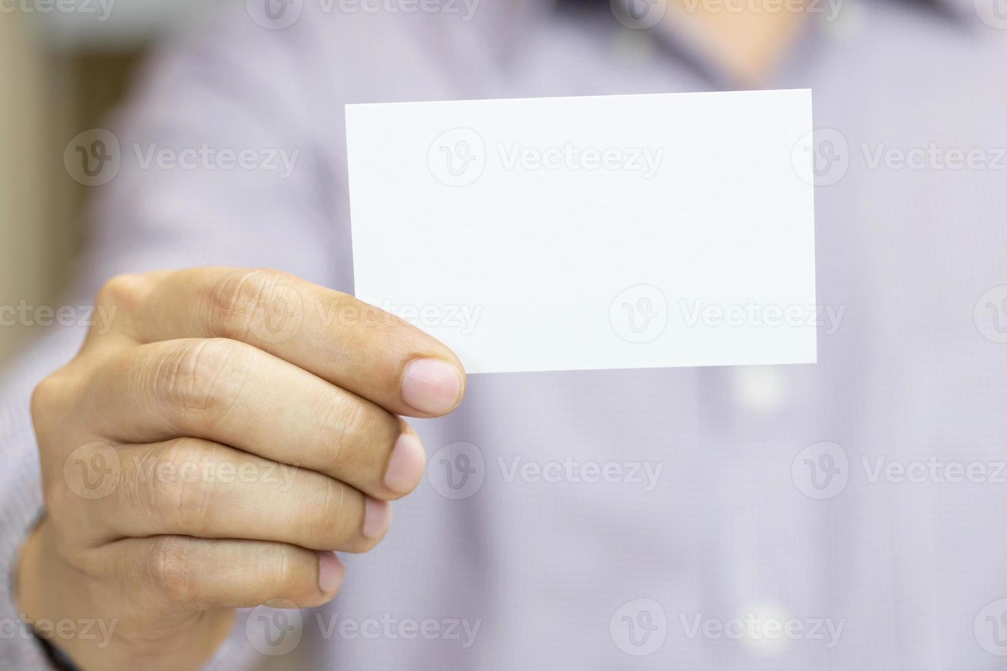 mann, der weiße visitenkarte auf betonwandhintergrund hält foto