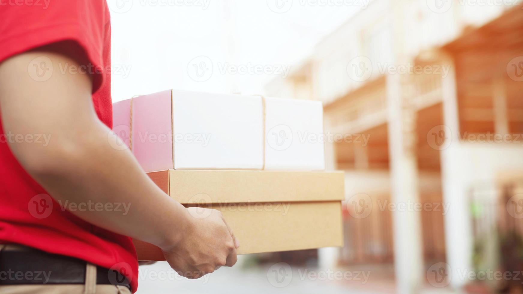 Lieferservice-Kurier klingelt mit Kisten in den Händen an der Haustür foto