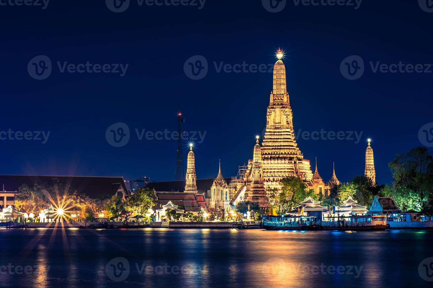 nächtliche ansicht des wat arun tempels über den chao phraya fluss in bangkok, thailand. foto