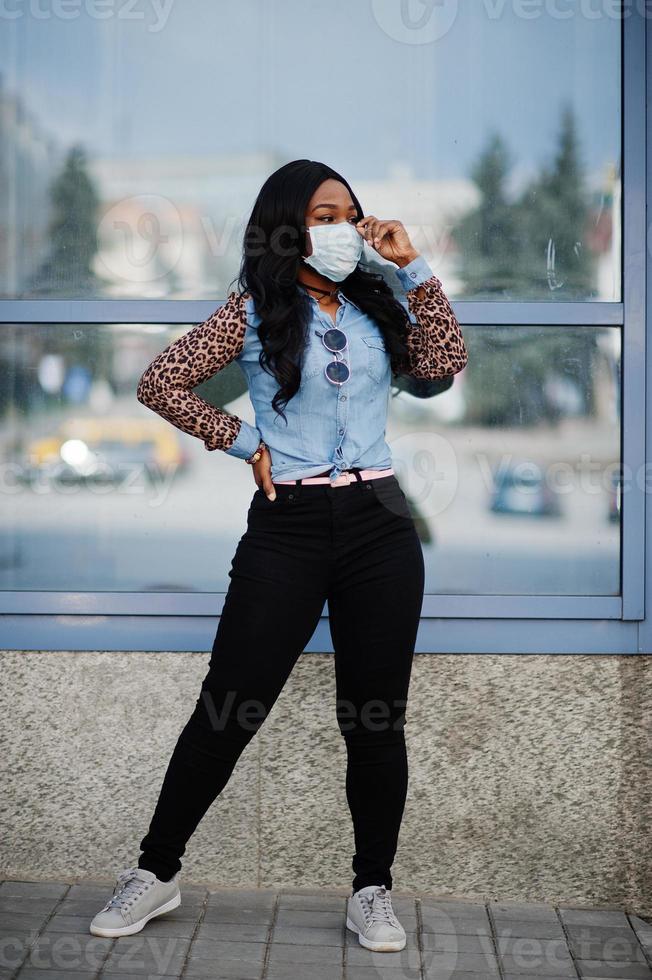 afroamerikanische junge freiwillige frau mit gesichtsmaske im freien. Coronavirus-Quarantäne und globale Pandemie. foto