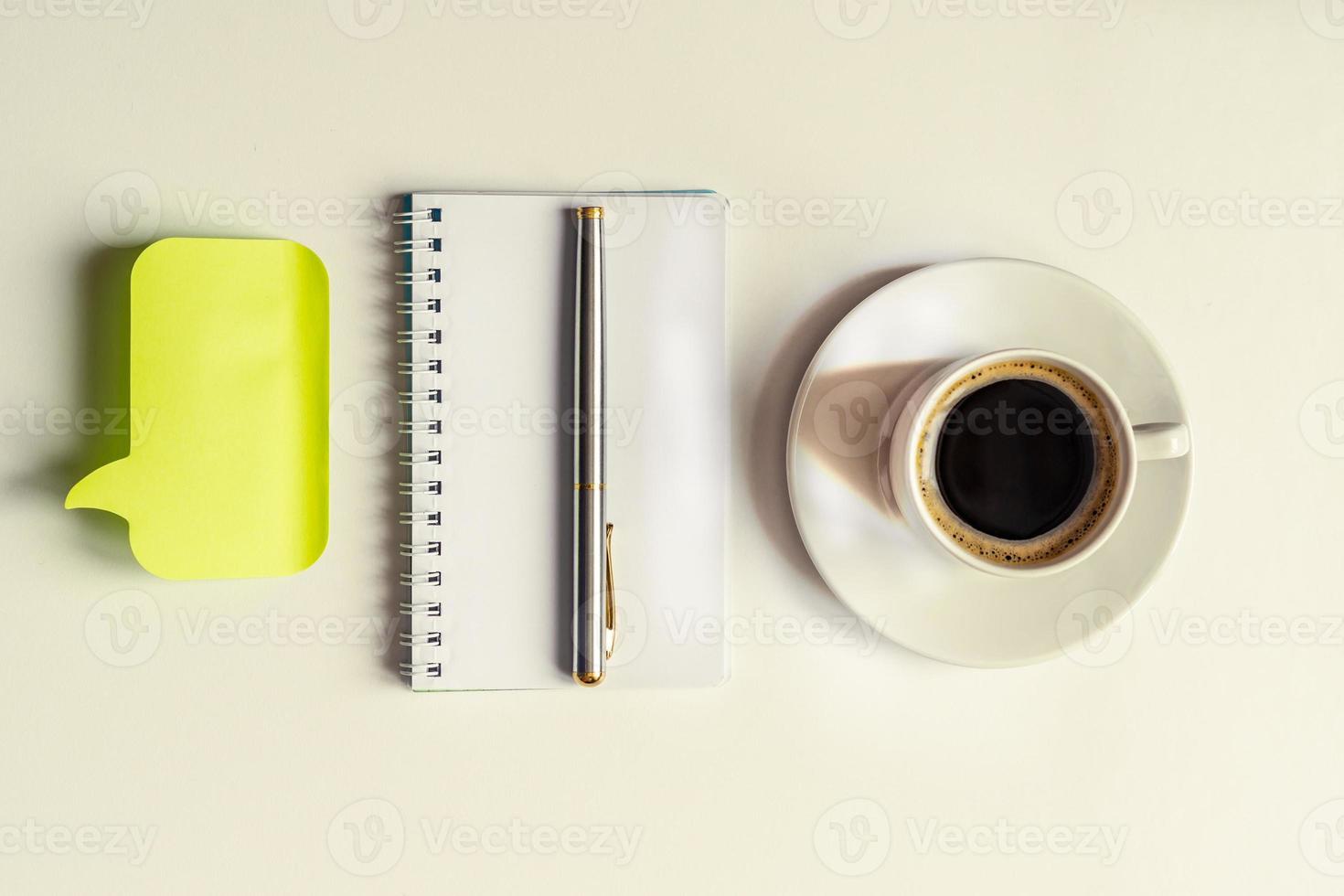 Draufsicht auf leeren Spiralnotizblock, silbernen Stift, gelben Aufkleber und Tasse Kaffee auf weißem Hintergrund. Geschäfts- oder Bildungskonzept foto