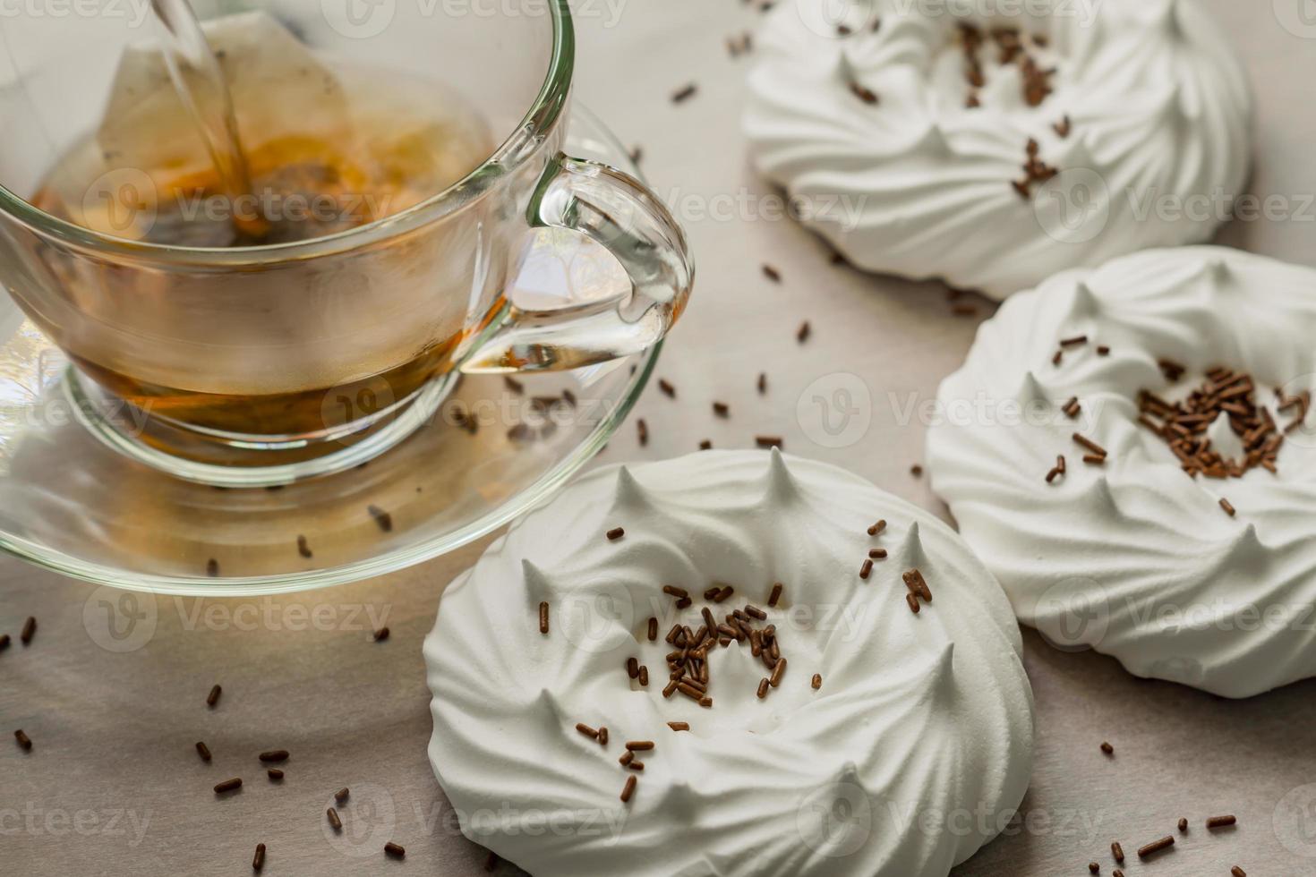 Schwarzer Tee in transparenter Tasse und Luft hausgemachte Meringues aus nächster Nähe foto