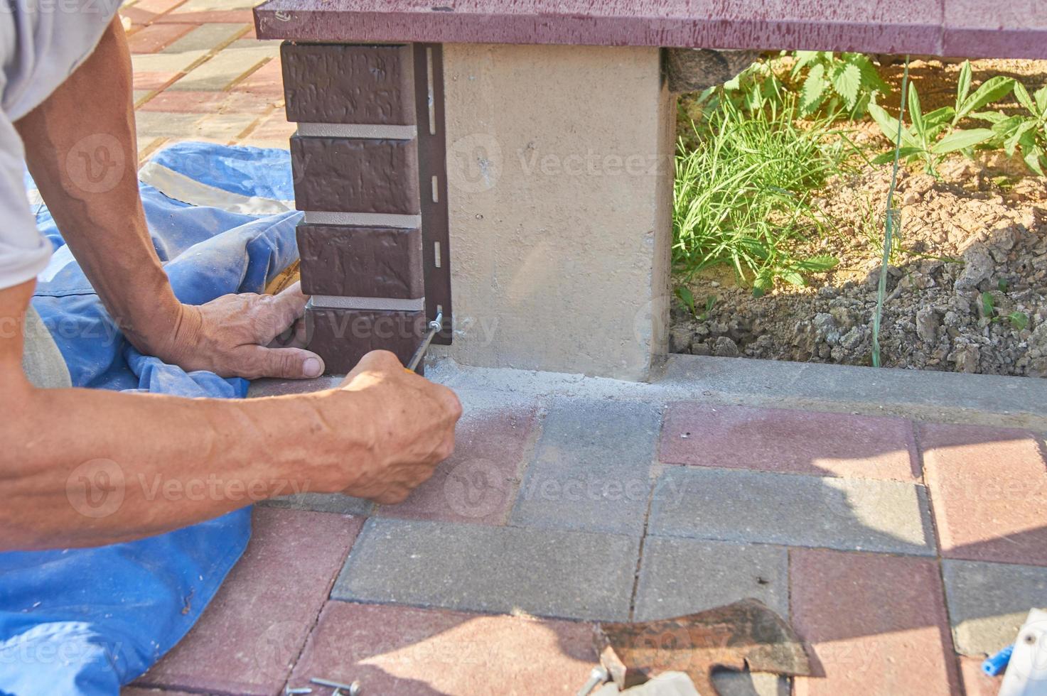 Ein Arbeiter installiert braune Paneele an der Fassade des Hauses foto