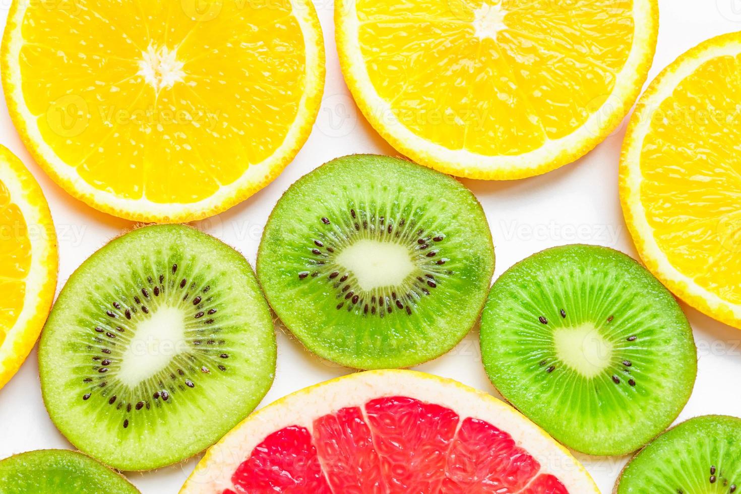 Zitrusscheiben - Kiwi, Orangen und Grapefruits auf weißem Hintergrund. Früchte Hintergrund foto