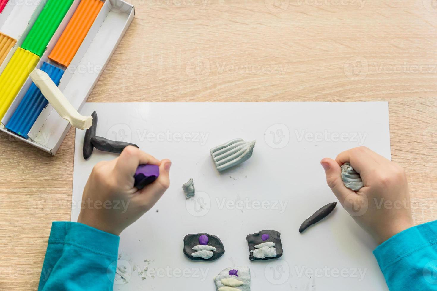 Hände eines kleinen Jungen, der mit bunter Knetmasse spielt. kreatives Kinderformen zu Hause. foto