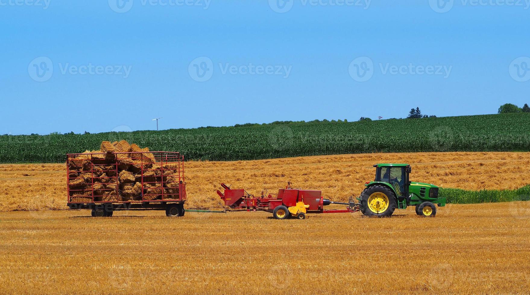 uns traktor, der stroh erntet foto