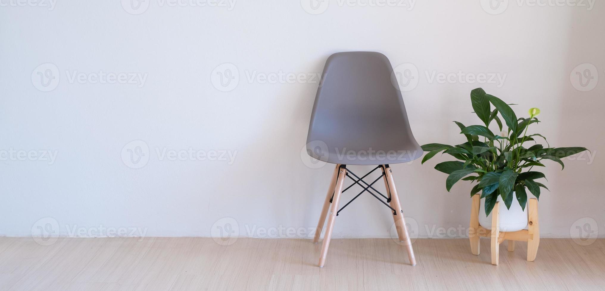graue Stühle und grüne Pflanzen auf dem Holzboden in einem minimalistischen Raum. foto
