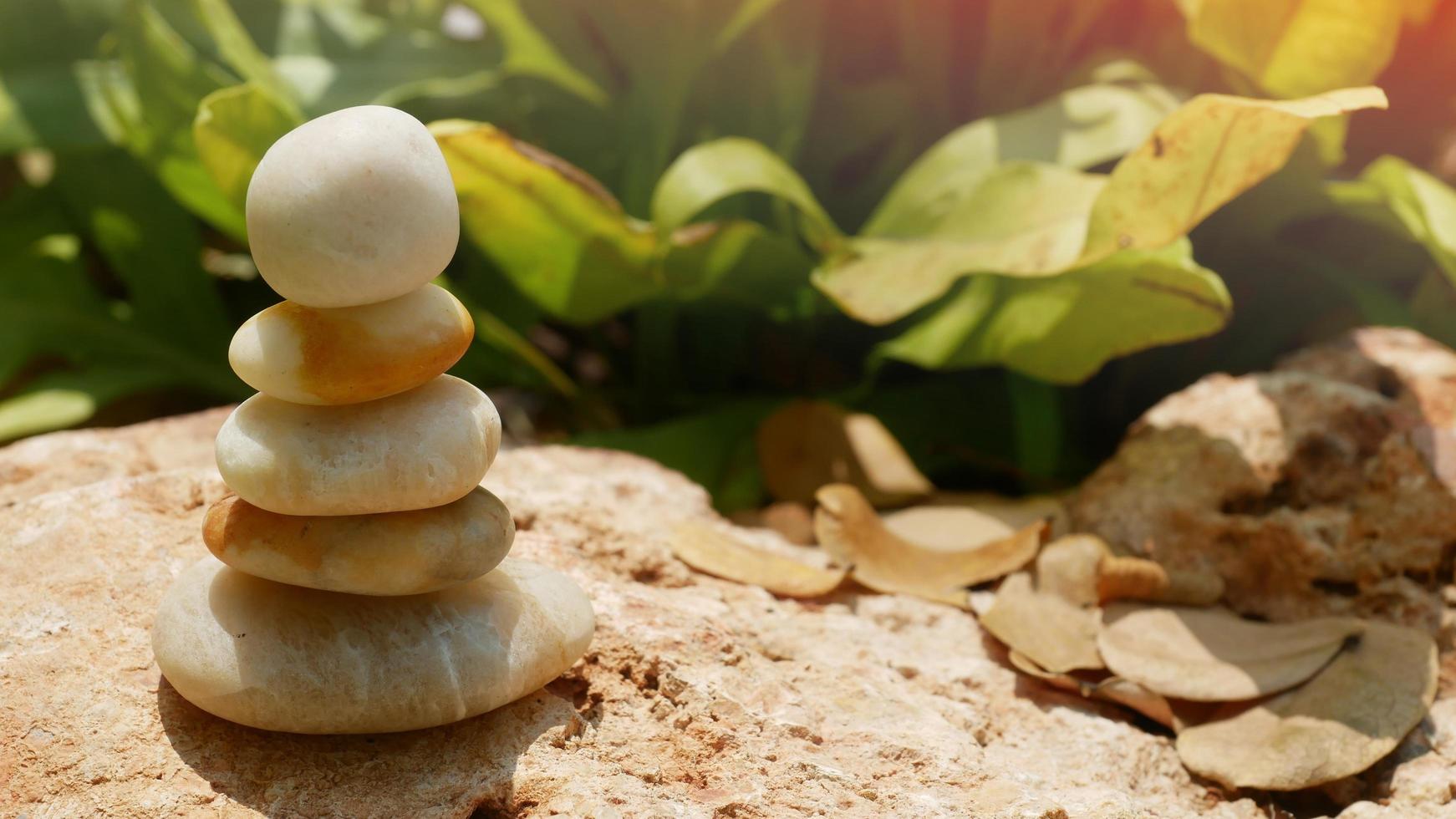 Die Ausgleichssteine sind als Pyramiden in einem weichen natürlichen Bokeh-Hintergrund gestapelt und repräsentieren das ruhige philosophische Konzept des Wohlbefindens des Jainismus. foto