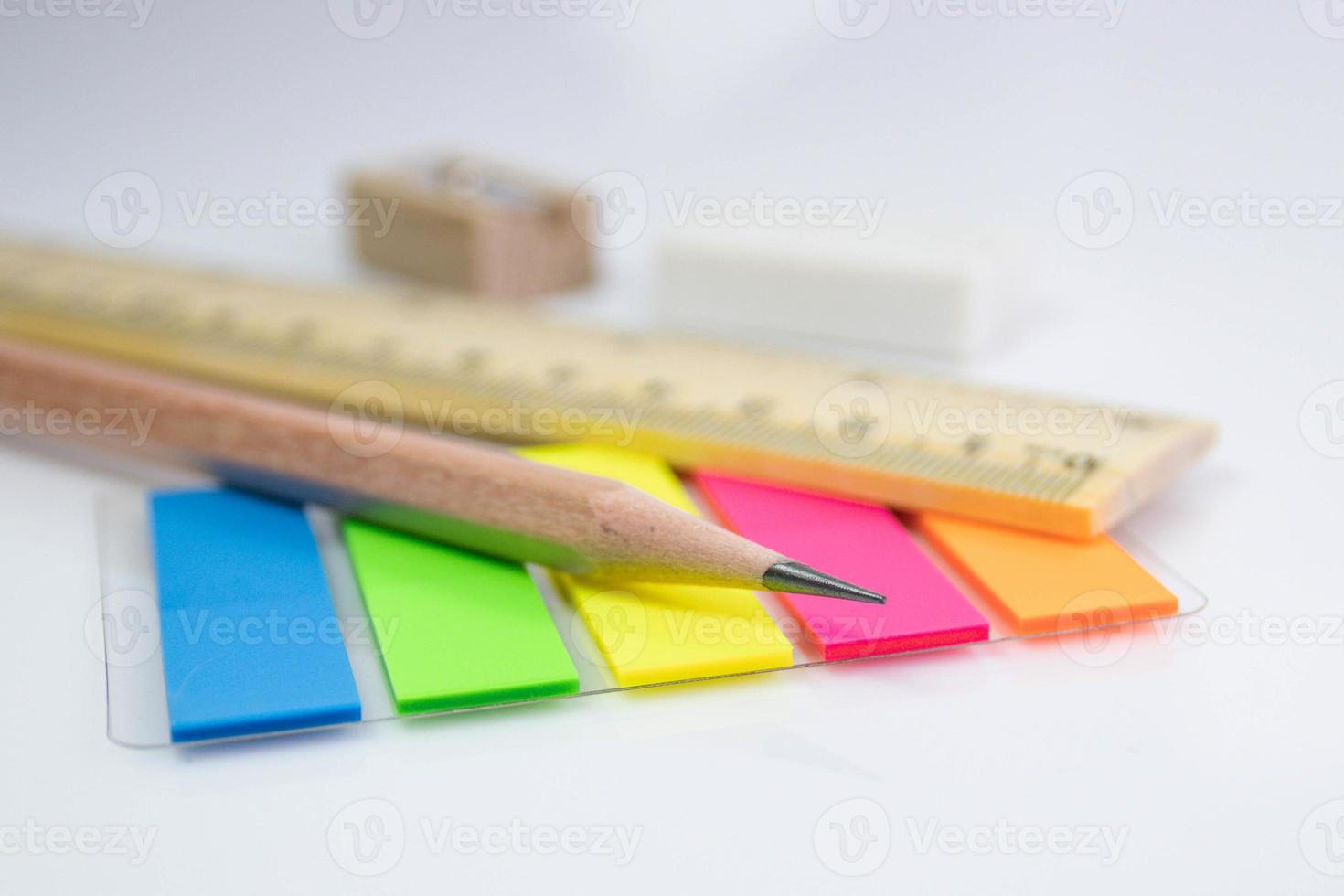 Nahaufnahme eines Bleistifts mit Papierfarbnotiz auf weißem Hintergrund foto