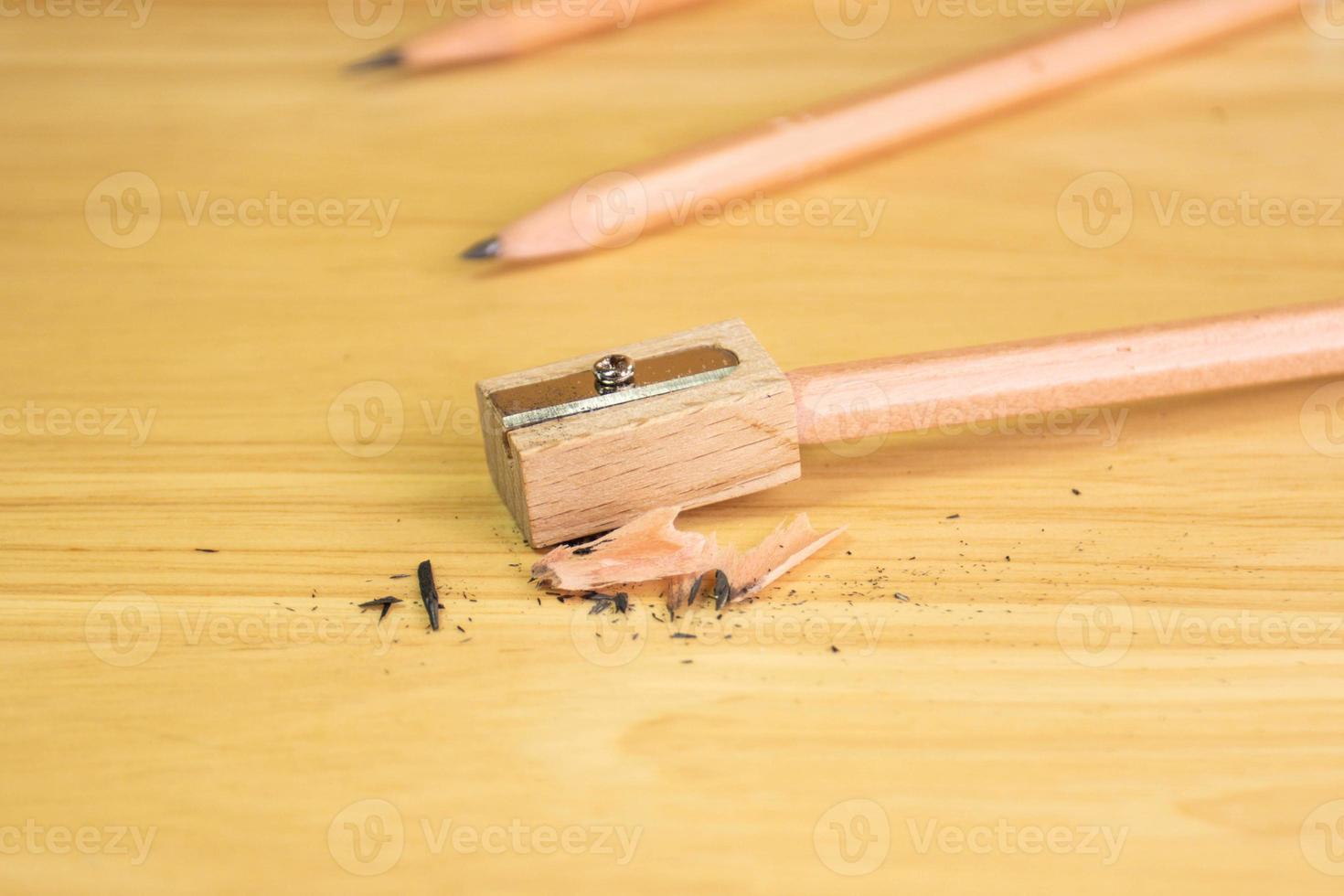 Bleistift und Anspitzer auf Holztisch foto