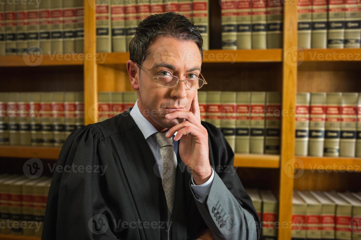 Anwalt, der Kamera in der Rechtsbibliothek betrachtet foto
