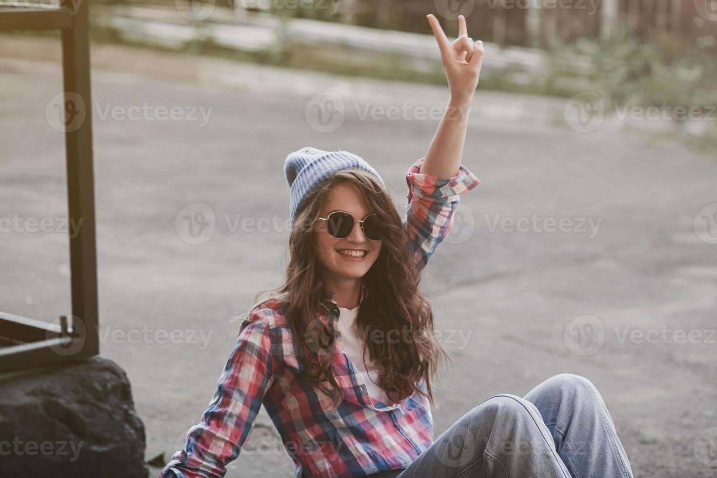 Hipster-Frau, die im städtischen Hintergrund lächelt foto