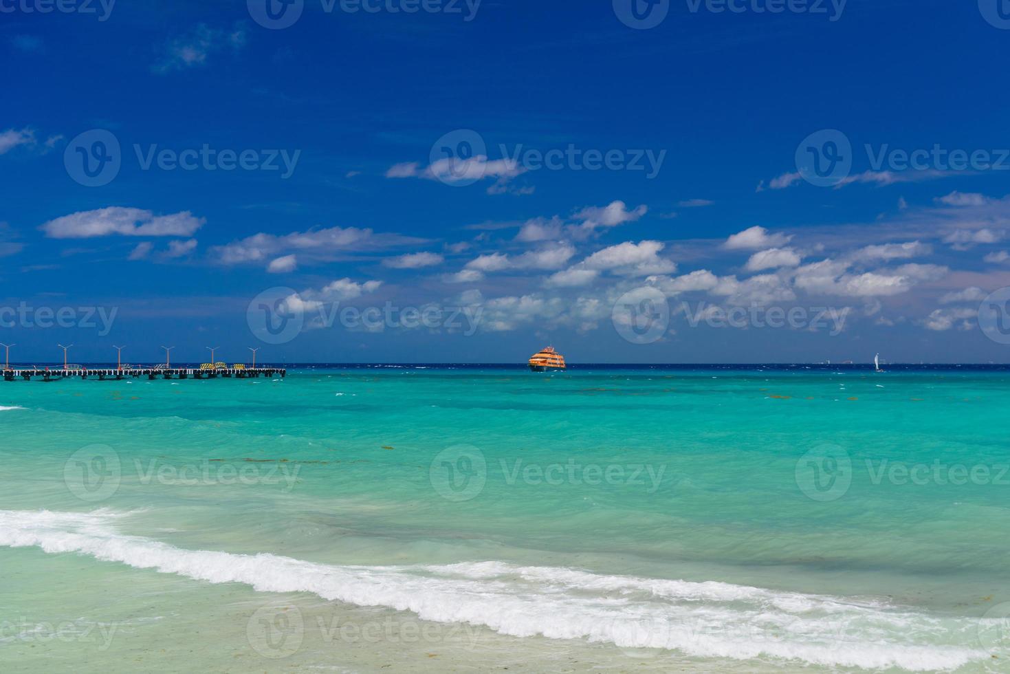 orange fähre im azurblauen ozean mit schwimmenden menschen in playa del carmen, yukatan, mexiko foto