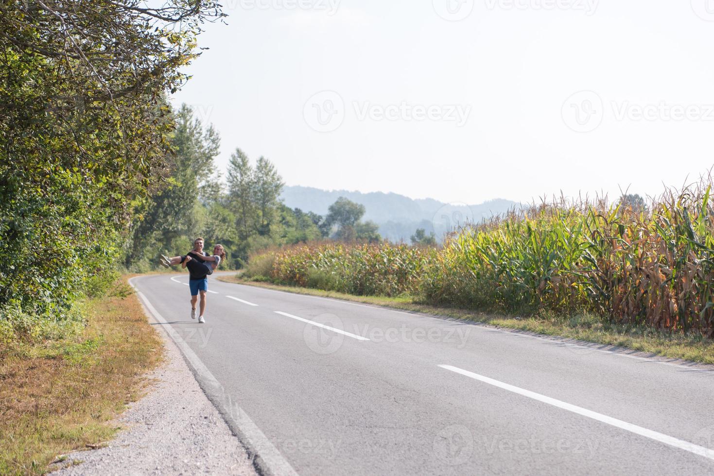 glückliches Paar beim Joggen auf einer Landstraße foto