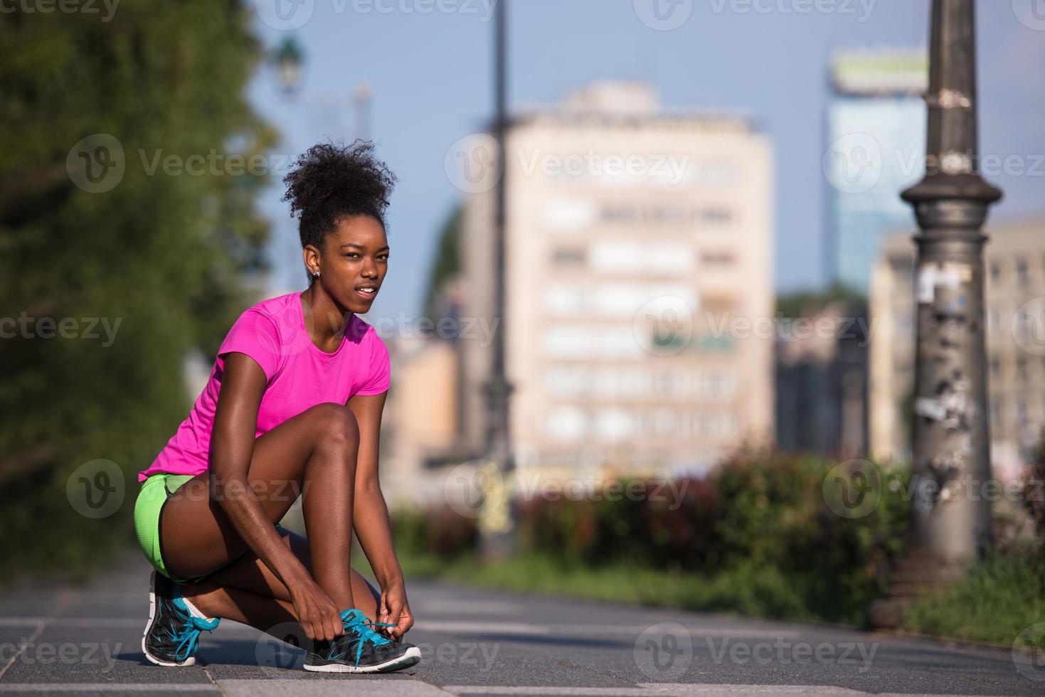 Afroamerikanische Läuferin, die Schnürsenkel anzieht foto