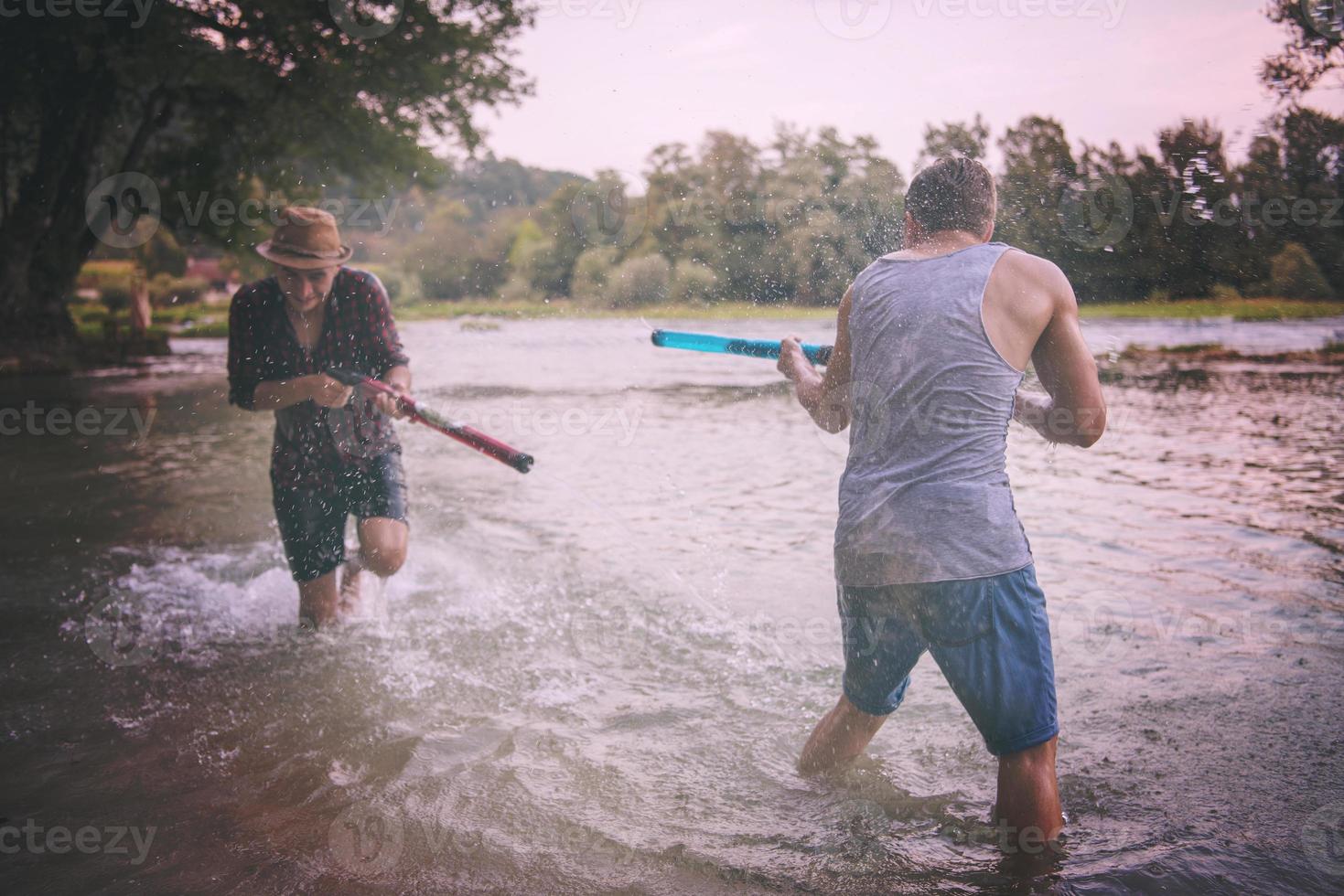 junge männer, die spaß mit wasserpistolen haben foto