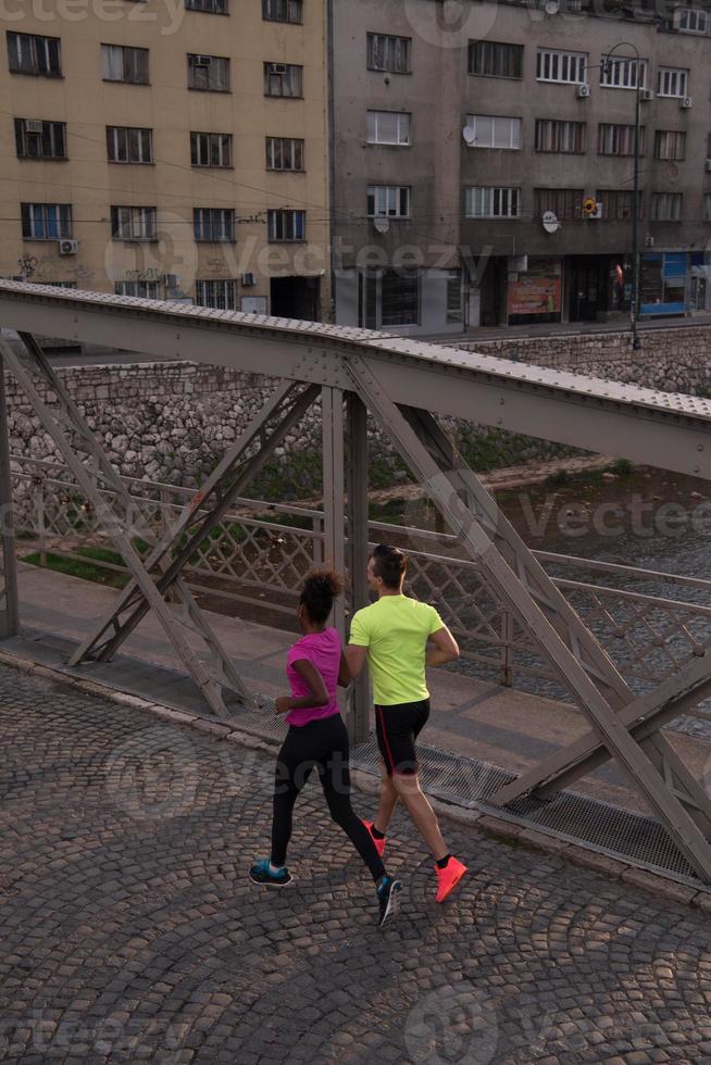 junges multiethnisches paar, das in der stadt joggt foto