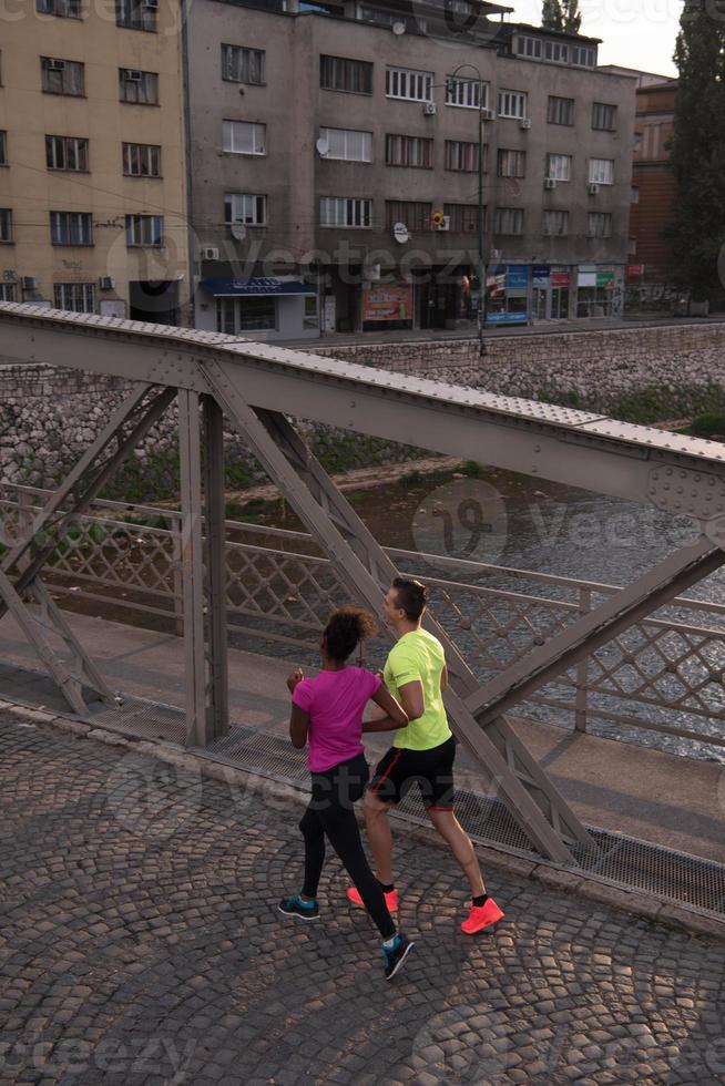 junges multiethnisches paar, das in der stadt joggt foto