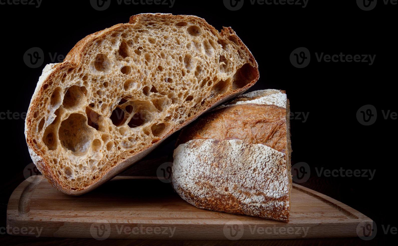 ein Laib Roggenbrot halbiert auf einem Holzbrett. foto