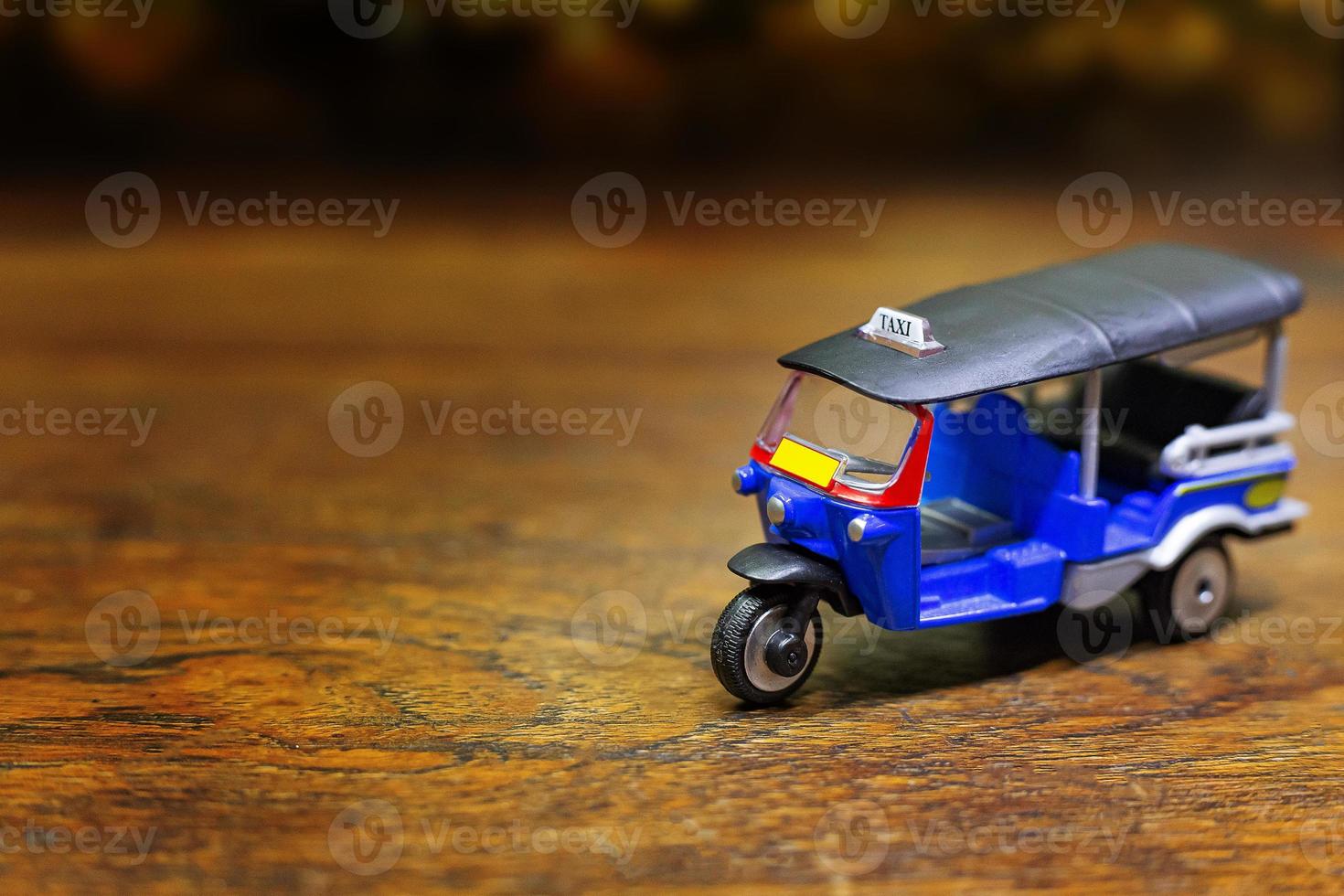 Tuk Tuk Taxi Spielzeug auf Holztisch Nahaufnahme Bild. foto