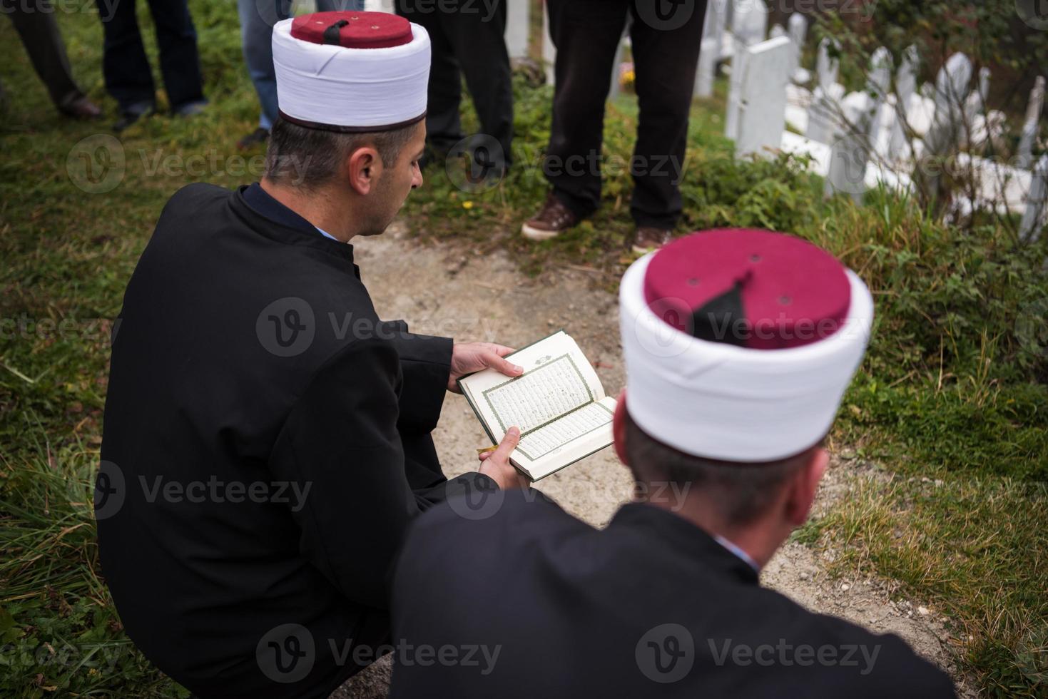 Koran-Heiligbuch-Lesung durch Imam bei islamischer Beerdigung foto