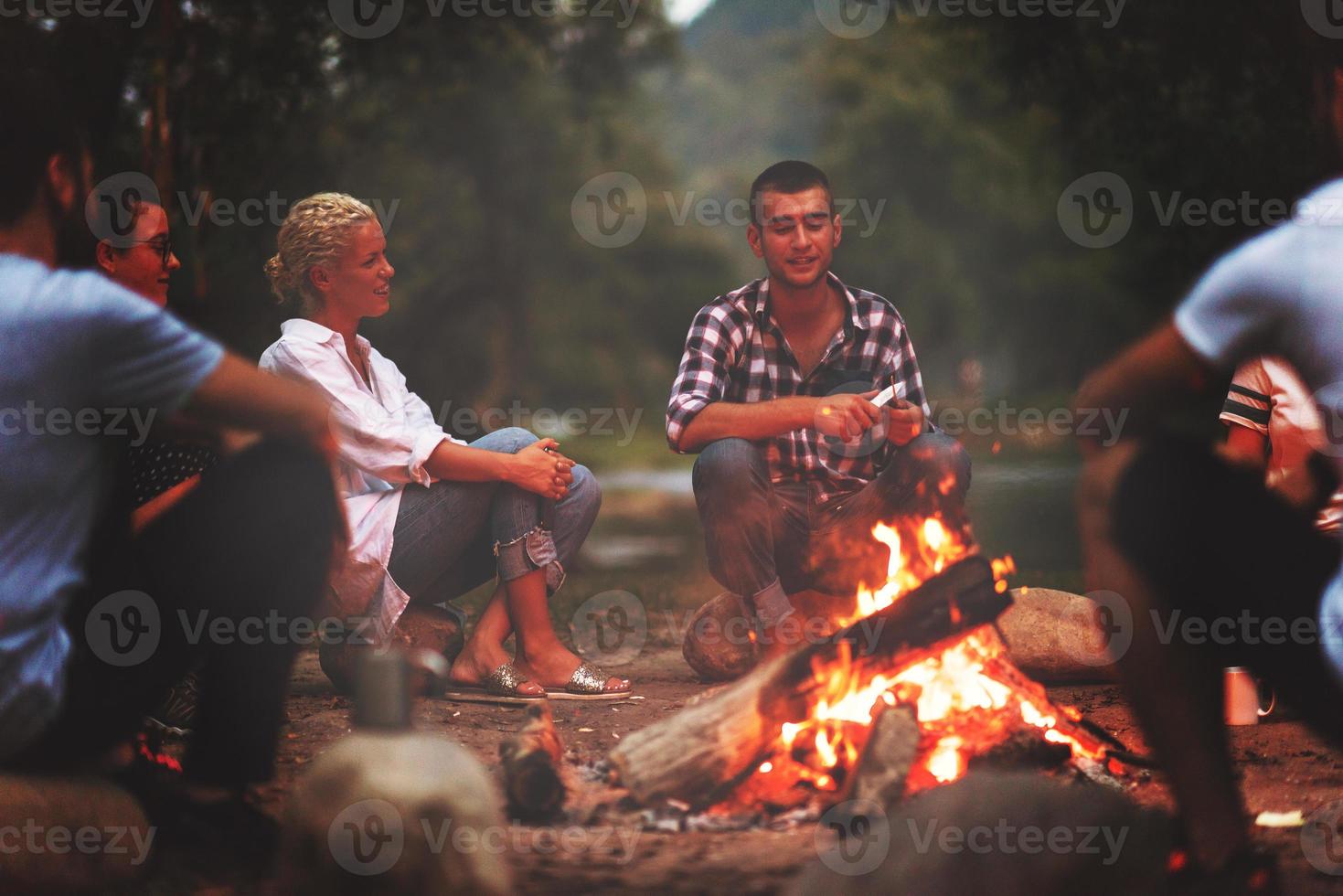 junge freunde, die sich am lagerfeuer entspannen foto