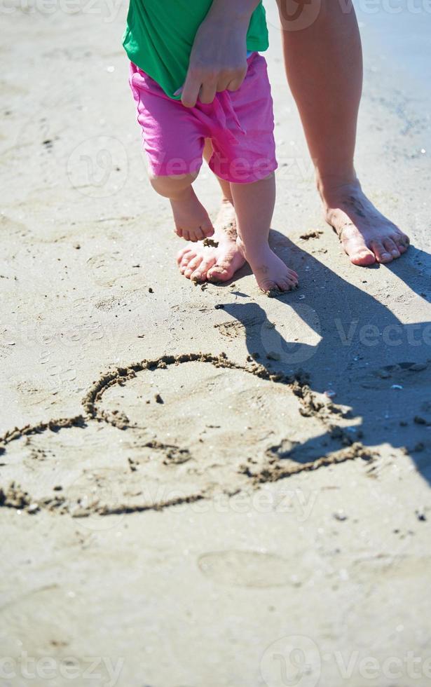 Mama und Baby am Strand haben Spaß foto