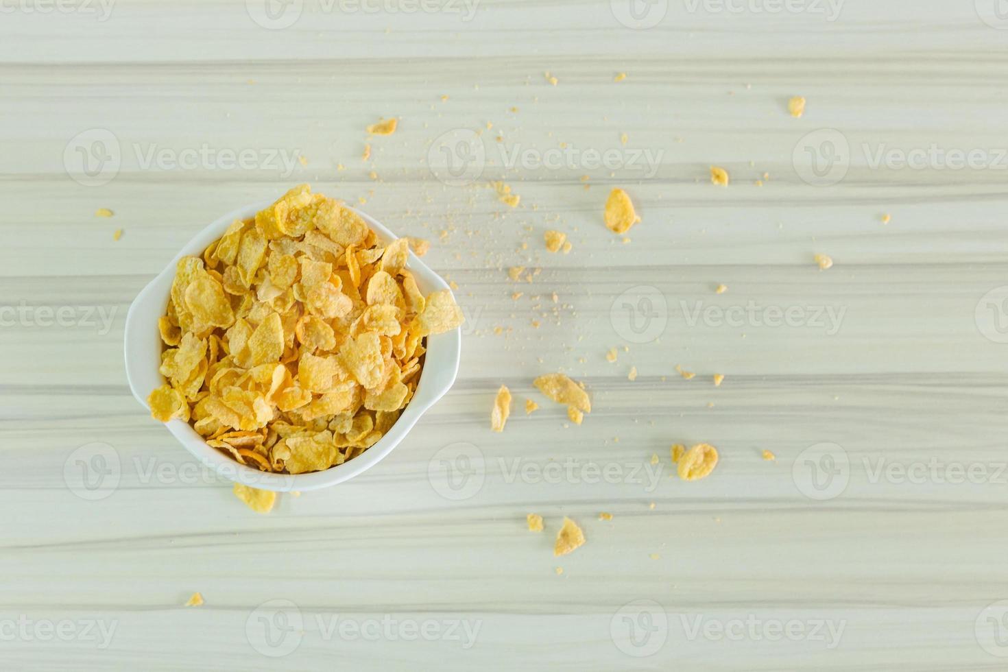 Bild Nahaufnahme Cornflakes Müsli Frühstück in weißer Schüssel auf Holztisch. foto