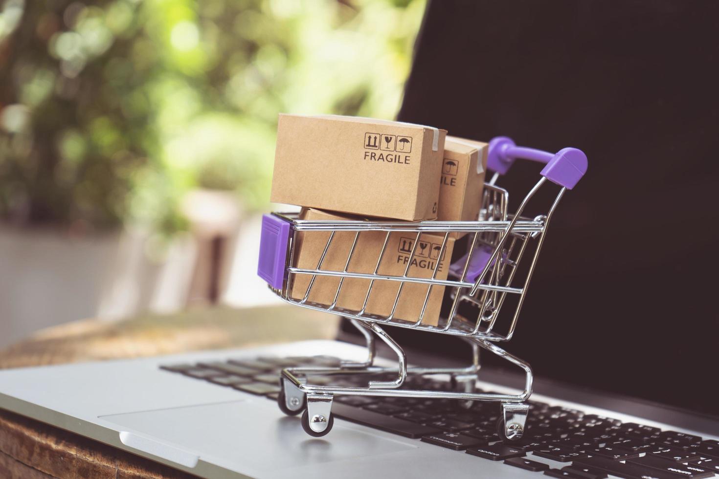 Online-Shopping oder E-Commerce-Lieferservice-Konzept, Papierboxen in einem Trolley auf einem Laptop-Computer, einfaches Online-Shopping-Konzept foto