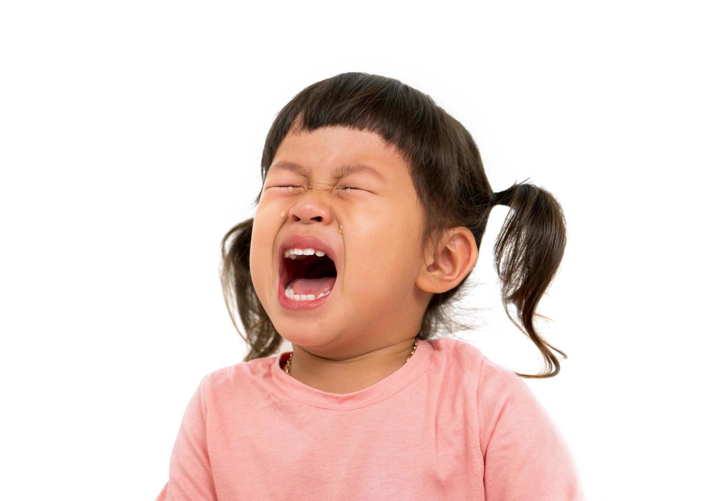 kleines asiatisches Mädchen weint auf weißem Hintergrund foto