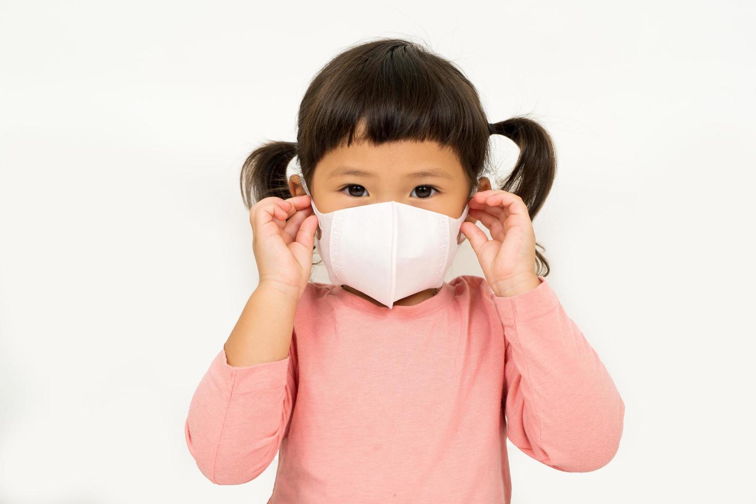 kleines asiatisches mädchen mit maske zum schutz des pm2.5- und coronavirus-konzepts foto