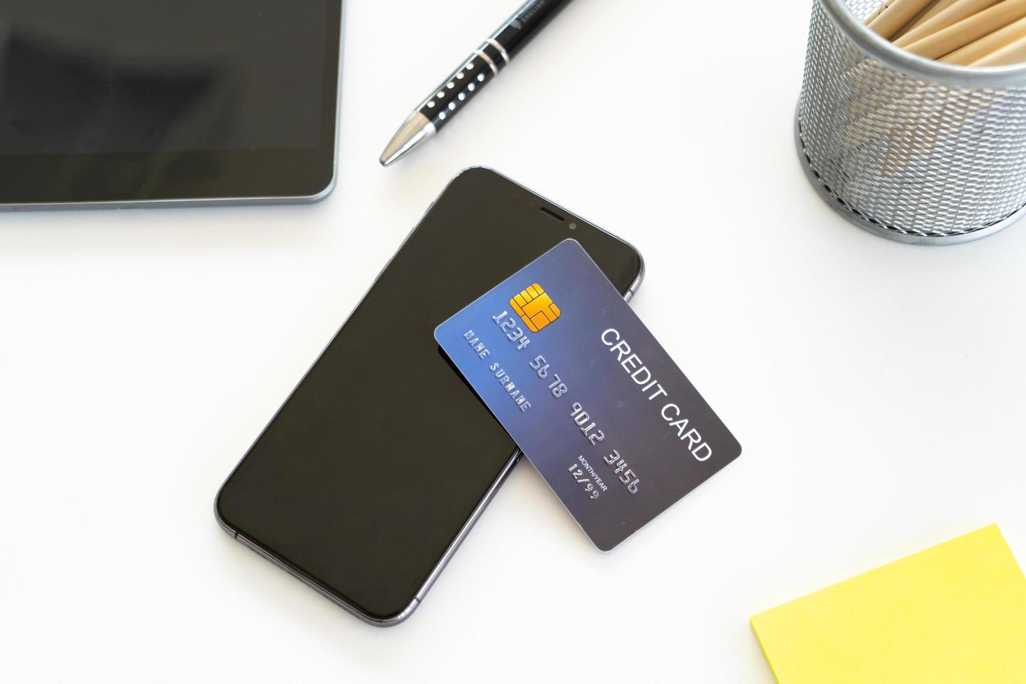Smartphone mit Kreditkarte auf Schreibtisch, Online-Shopping-Konzept foto