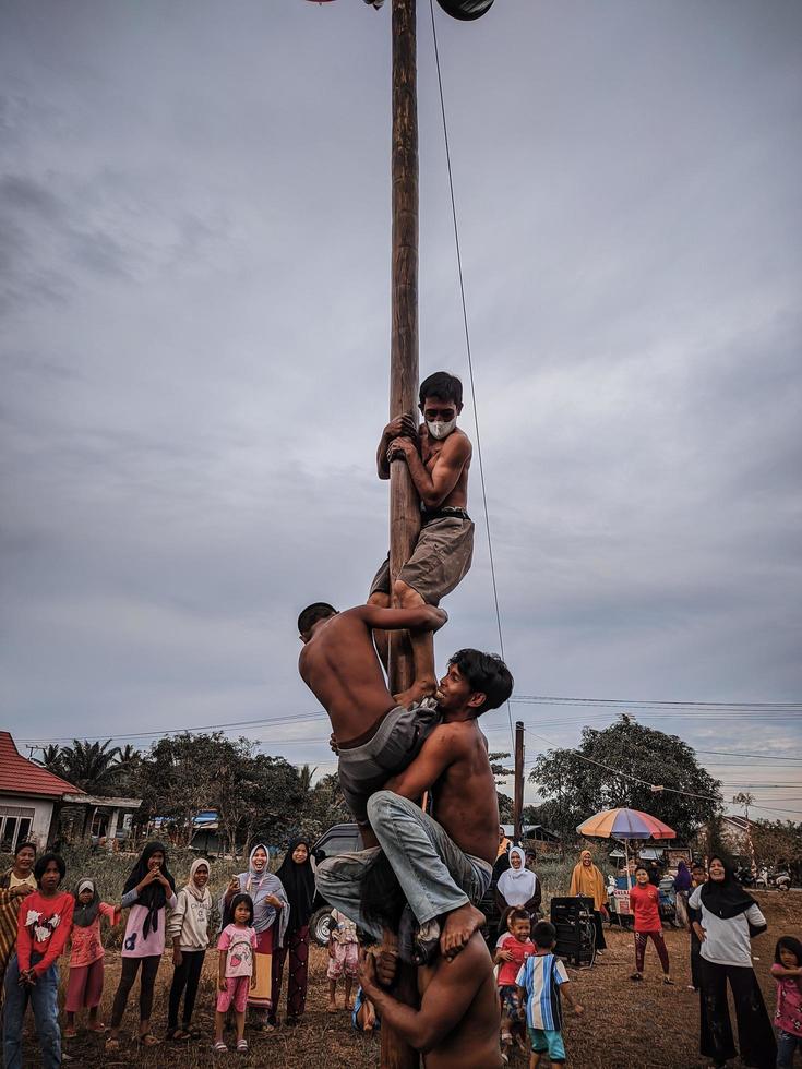 die aufregung von kindern und erwachsenen, die am areca-kletterwettbewerb teilnehmen, um den unabhängigkeitstag der republik indonesien, ostkalimantan, indonesien, august, 14,2022, zu beleben foto