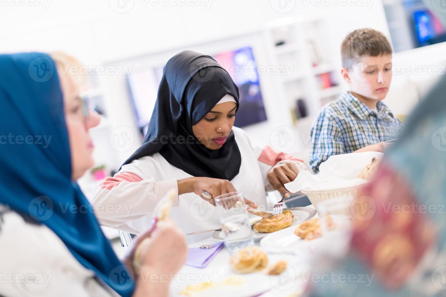 schwarze moderne muslimische frau, die iftar-abendessen mit der familie genießt foto