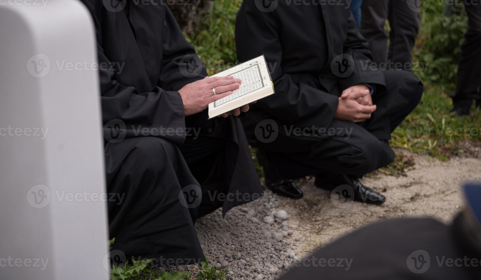 Koran-Heiligbuch-Lesung durch Imam bei islamischer Beerdigung foto