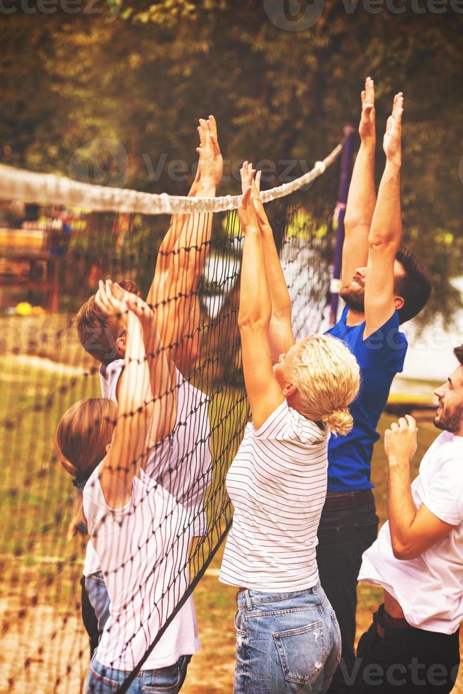 gruppe junger freunde, die beachvolleyball spielen foto