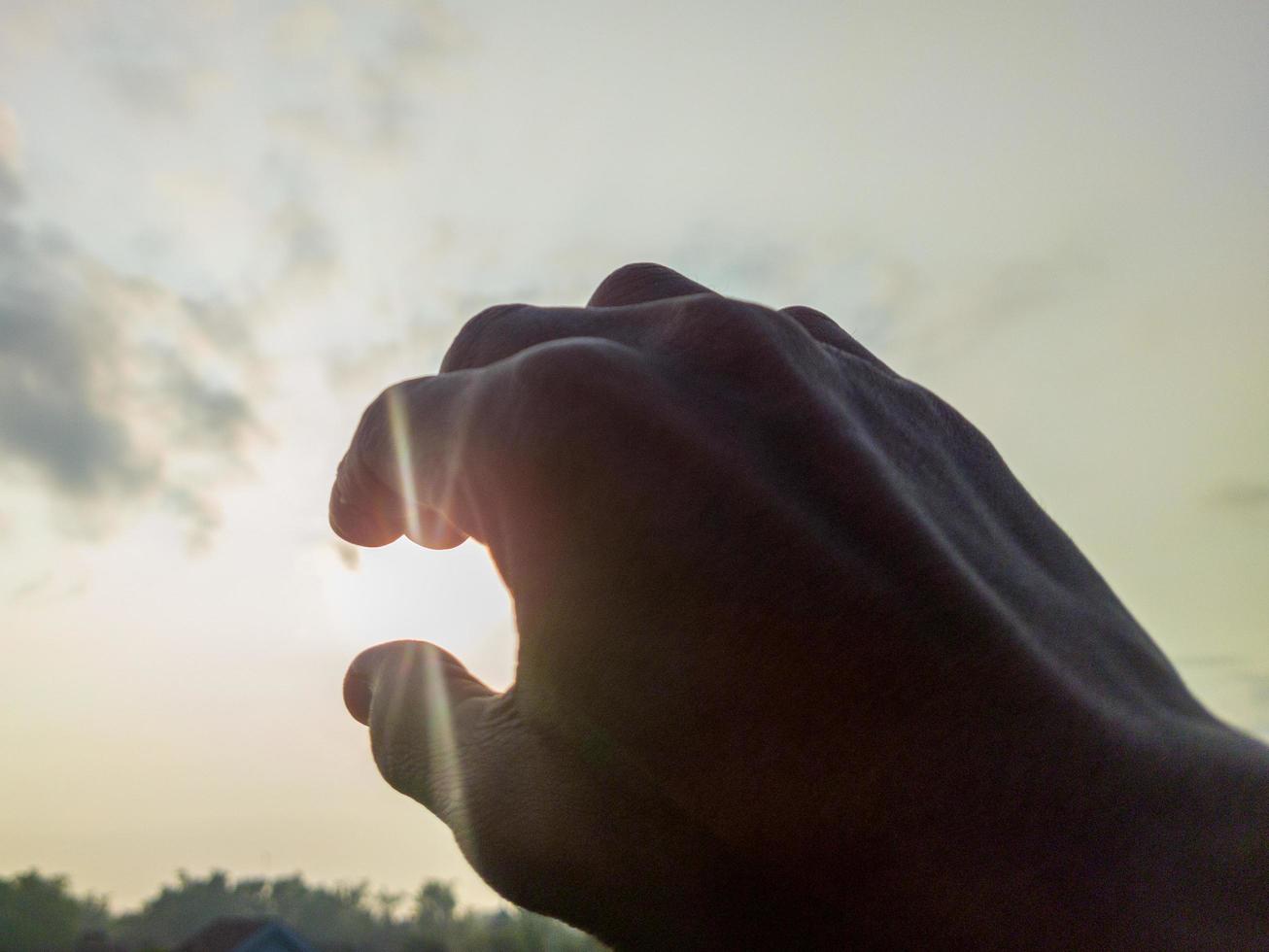 Eine Hand will die Sonne halten foto