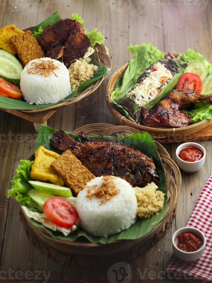 Köstliches, frisch gegrilltes Huhn und Fisch werden appetitlich auf einem Holzteller serviert foto