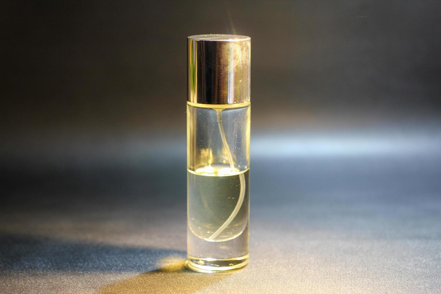 transparente Parfümflasche im Fotostudio, klare Parfümglasflasche mit Sprühverschluss foto