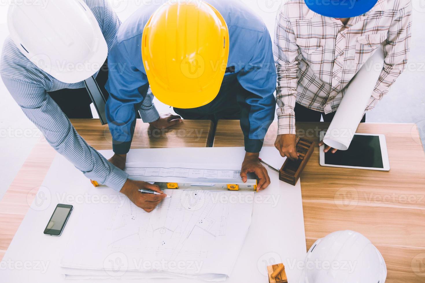 team von ingenieuren diskutiert architekturplanskizze auf der baustelle. foto