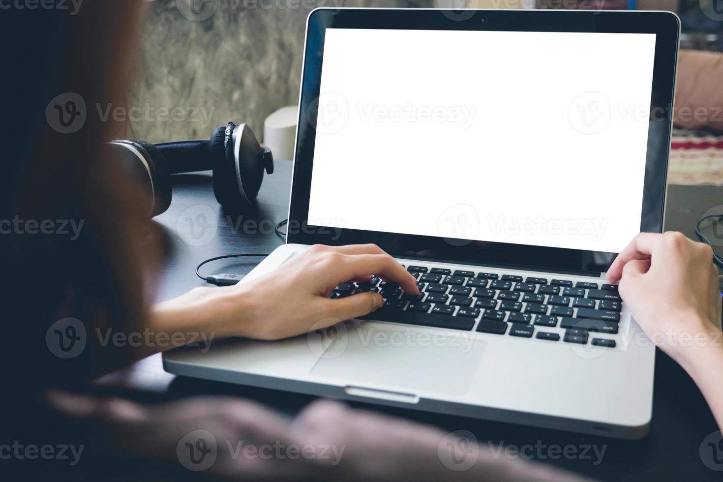 Nahaufnahme von weiblichen Händen mit Laptop mit leerem Bildschirm auf dem Schreibtisch. foto