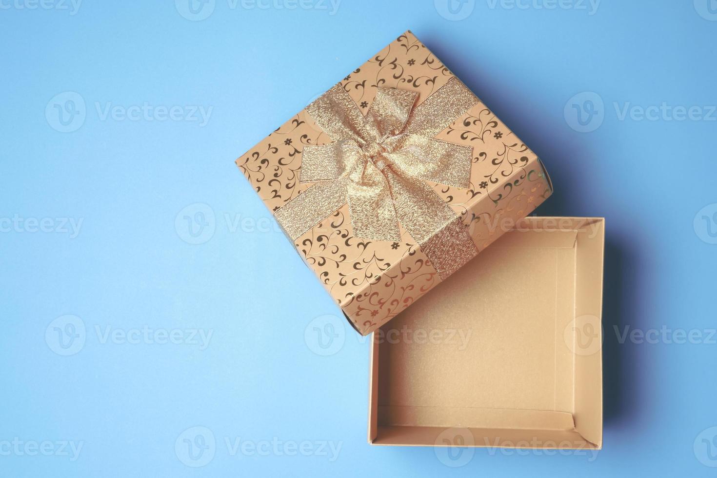 Draufsicht der offenen Geschenkbox auf blauem Hintergrund. Freiraum für Text foto