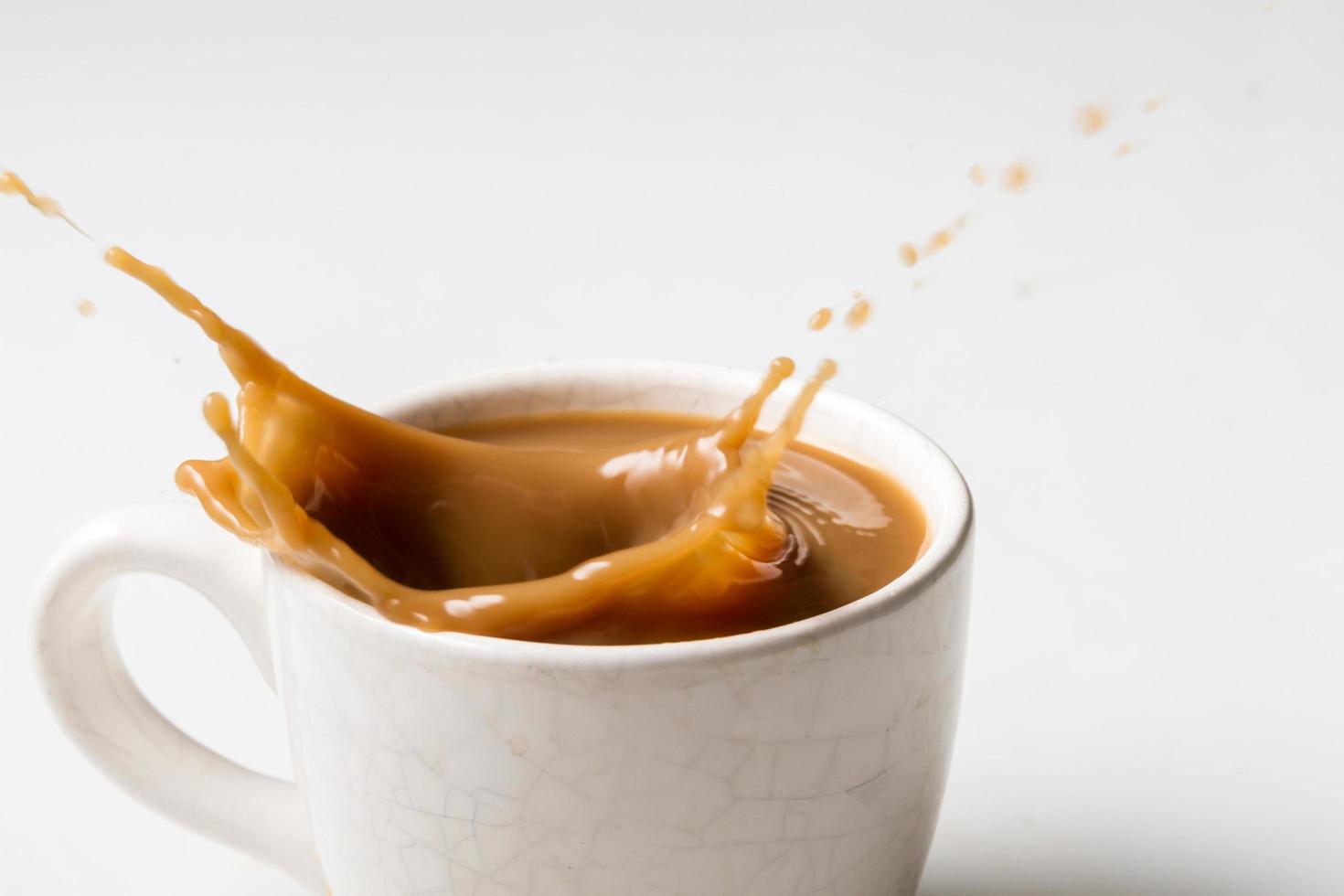 Tasse spritzenden Kaffee auf weißem Hintergrund foto