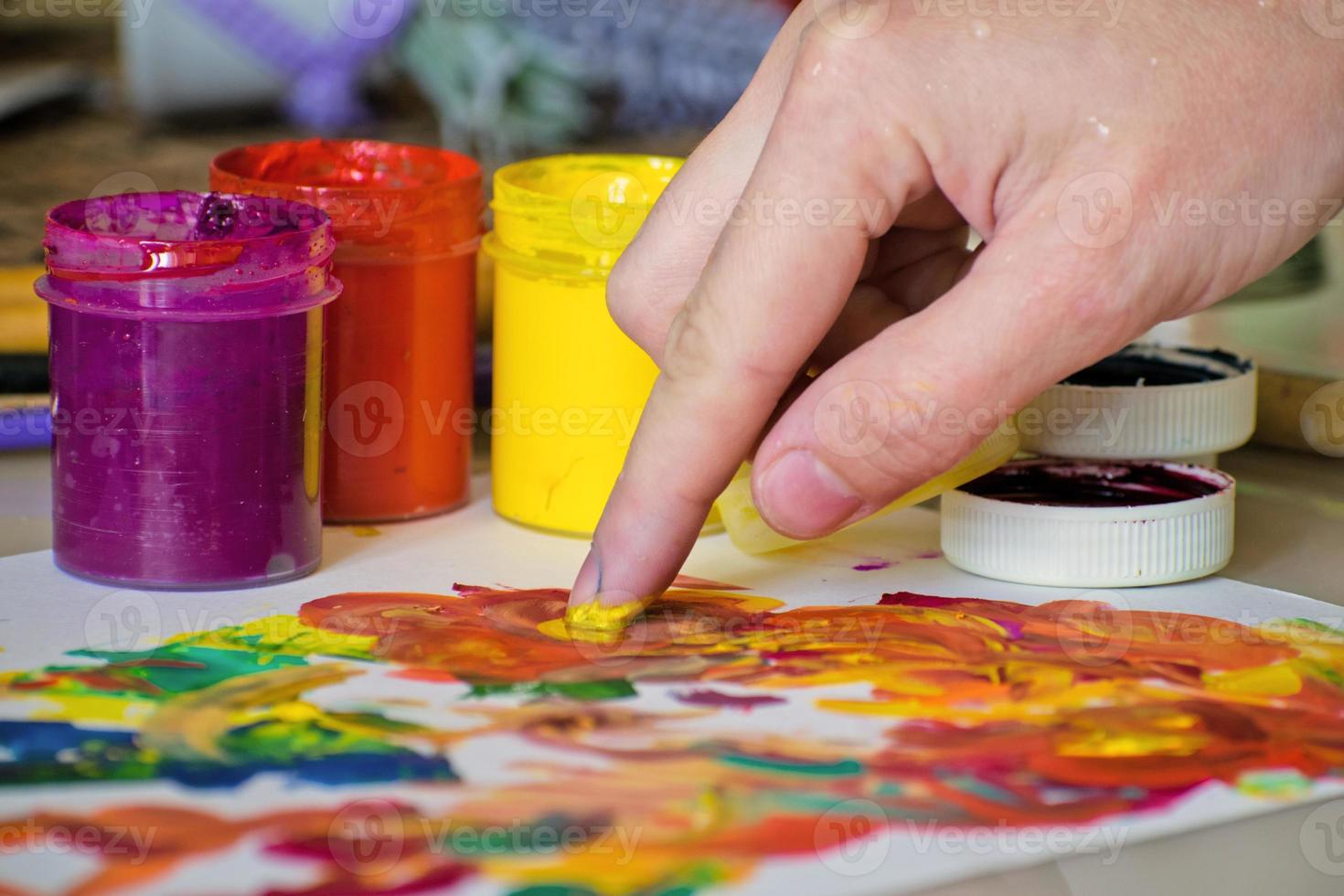 Hand eines Mädchens, das Farben mit den Fingern zum Malen mischt. abstrakte Malerei mit Gouache. Fingerfarbe foto