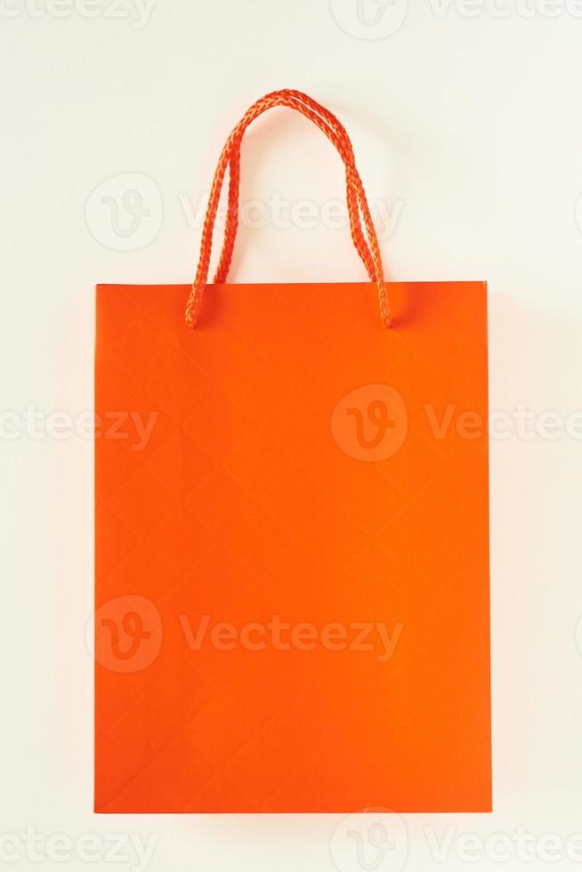 Mockup der orangefarbenen Papiereinkaufstasche auf weißem Hintergrund foto
