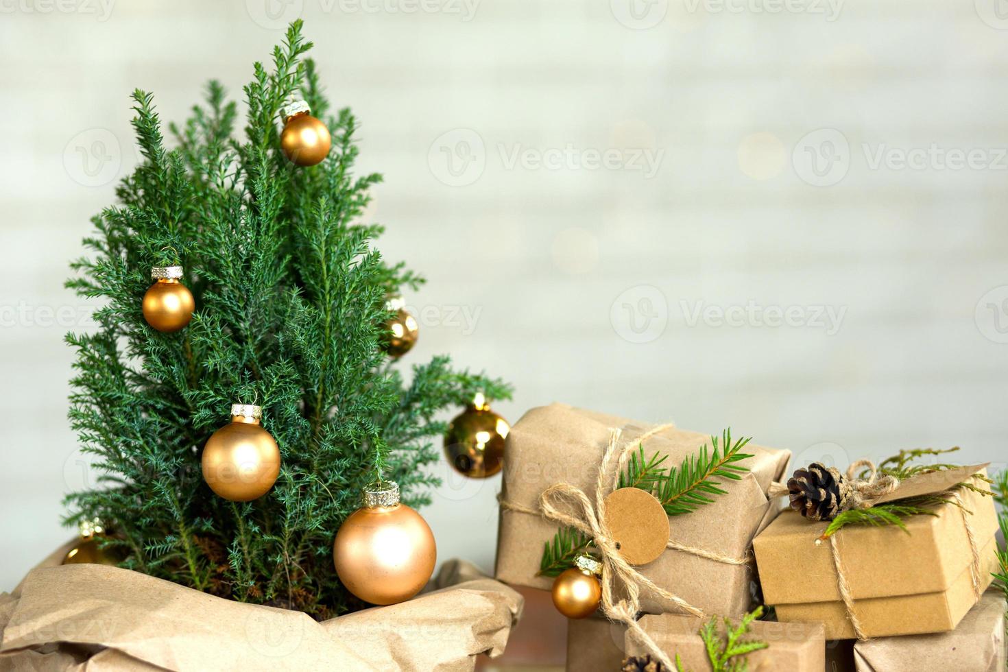 Indoor-Zypresse im Topf ist dekorierte Kugeln wie Weihnachtsbaum mit Lichterketten. geschenkboxen mit natürlichem dekor für neujahr und weihnachten. umweltfreundlich, abfallfrei, heimische Pflanze, Gewächshaus. Platz kopieren foto