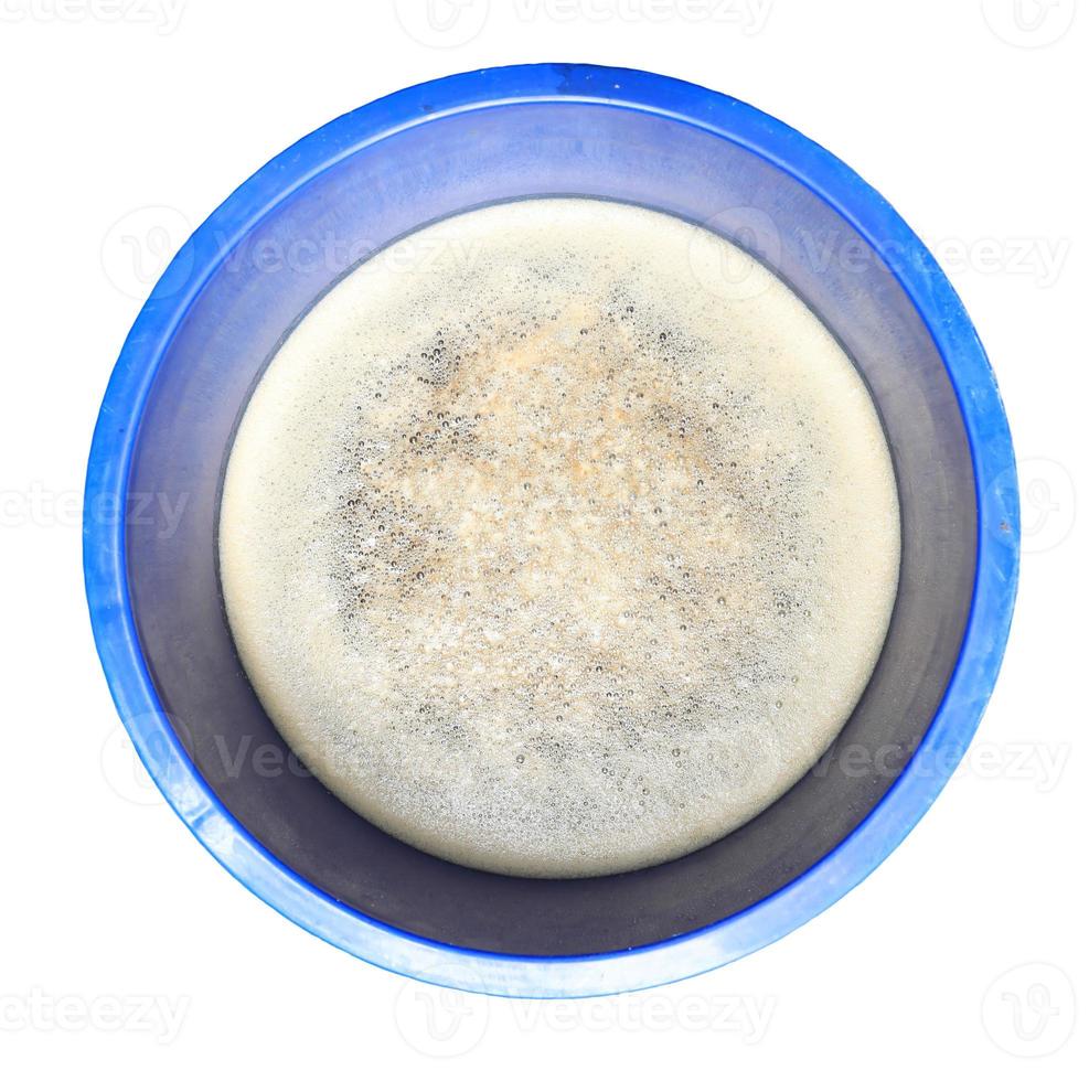 Oberflächen von Blasen oder Schaum bedecken schmutziges Wasser. im blauen Behälter isoliert. foto